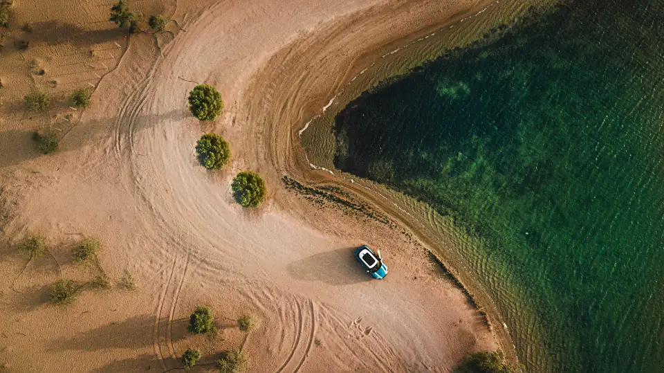 Aerial view of a sandy coastline and water shot from a drone