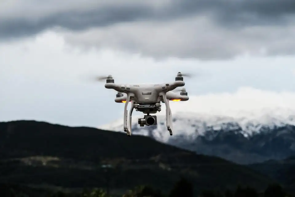 Camera drone in flight near snowy mountains