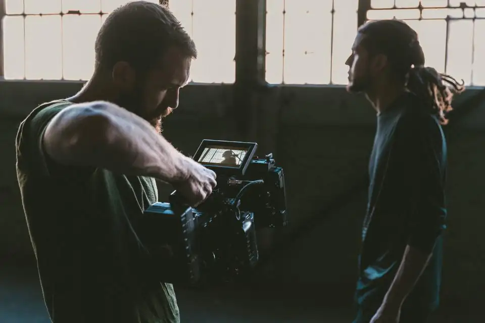 Camera operator framing a shot of on-camera talent on location