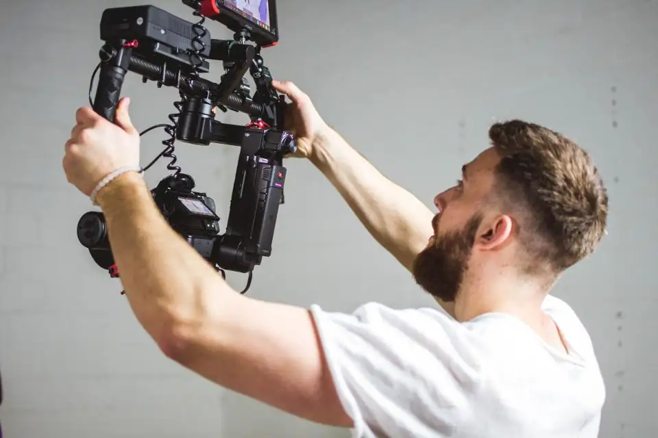 Camera operator holding a gimbal rig in a studio