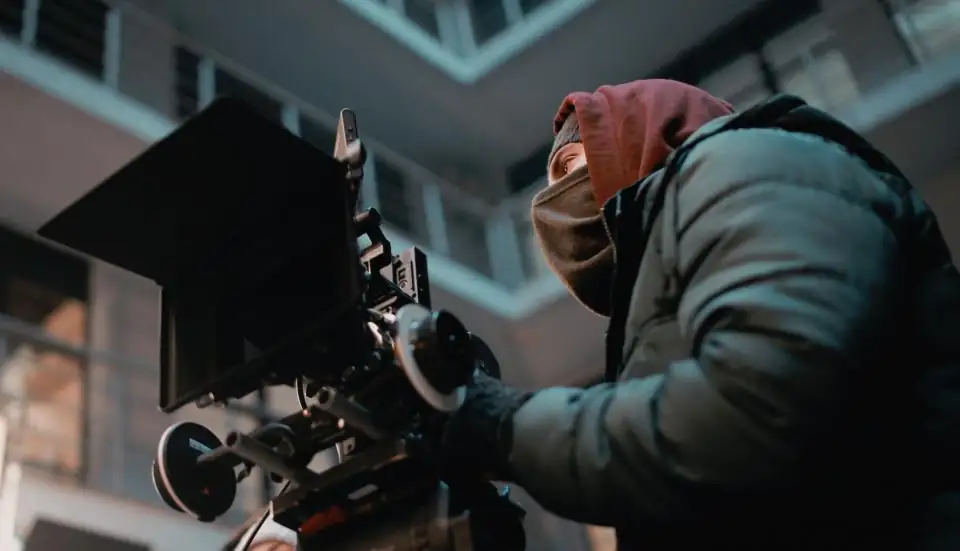 Crew member operating a rigged cinema camera