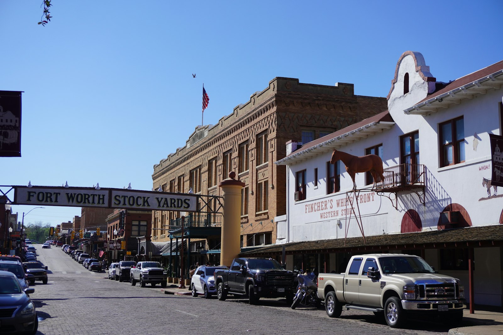 Historic brick storefronts and pickup trucks on East Exchange Avenue in the Fort Worth Stockyards