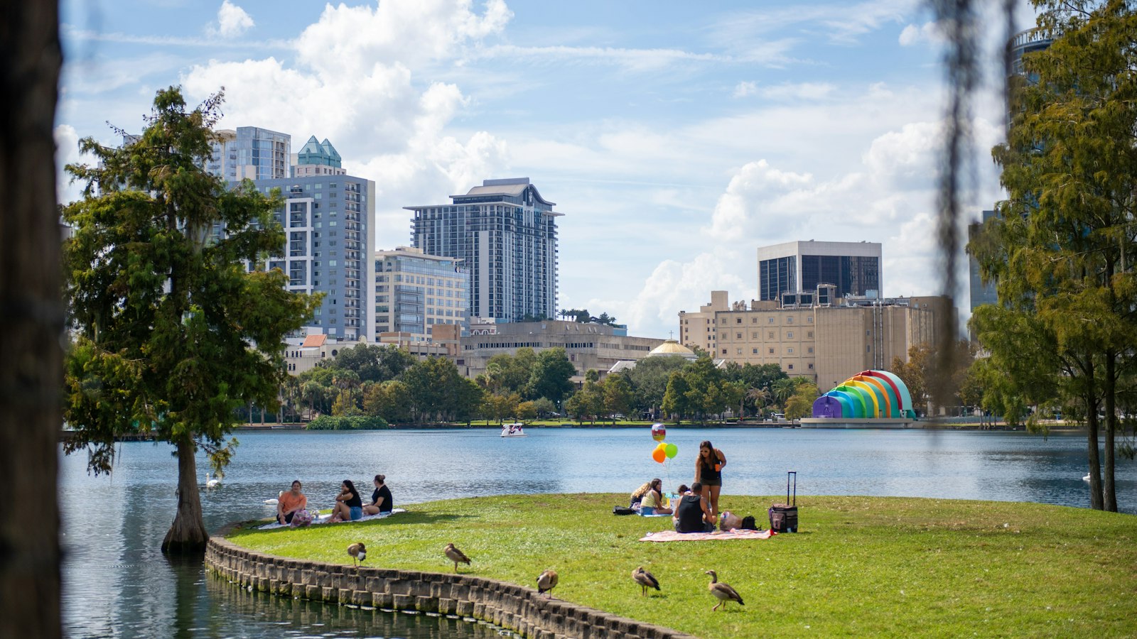 Downtown Orlando towers seen from a lakeside lawn